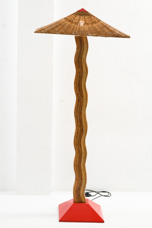 A 'Pallete' floor lamp with a curved wicker shade and a turquoise base, standing upright against a light background.