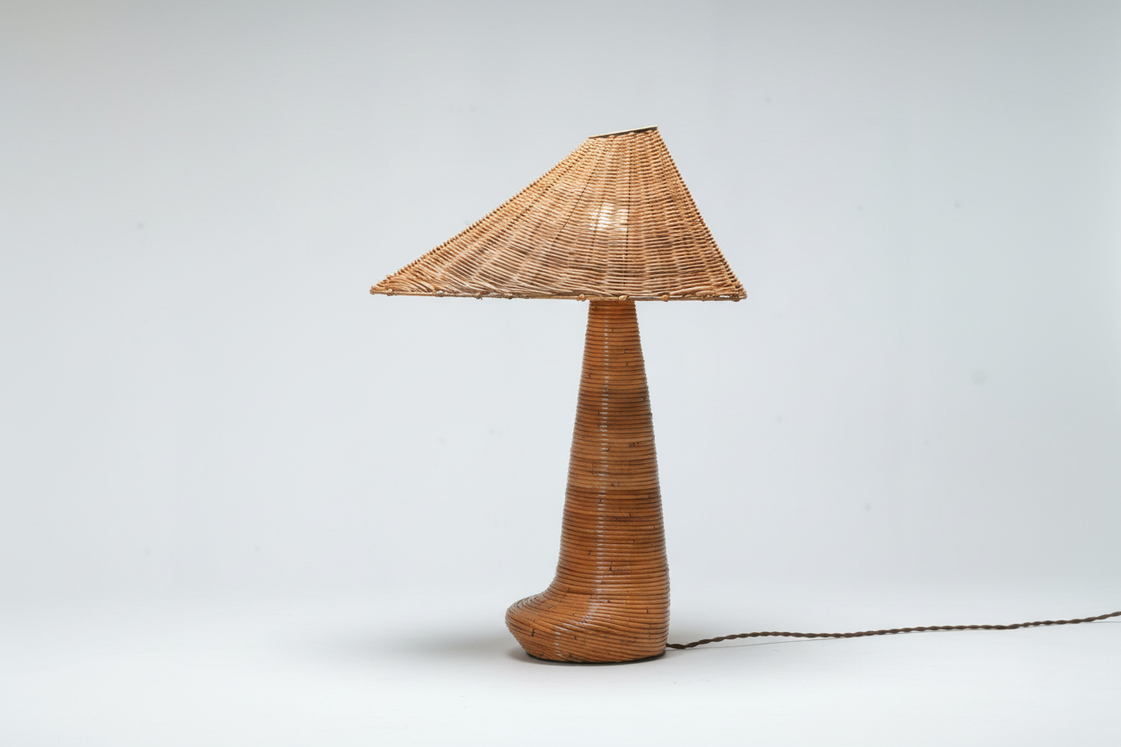 Wicker table lamp on a wooden surface with a light gray background