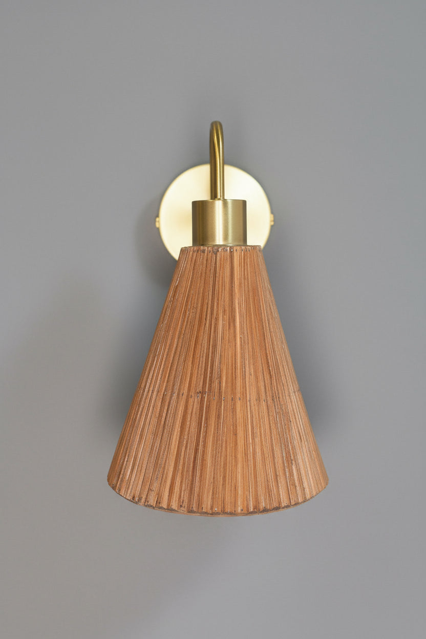 Wall sconce with cone- shaped rattan shade and brass fixture o