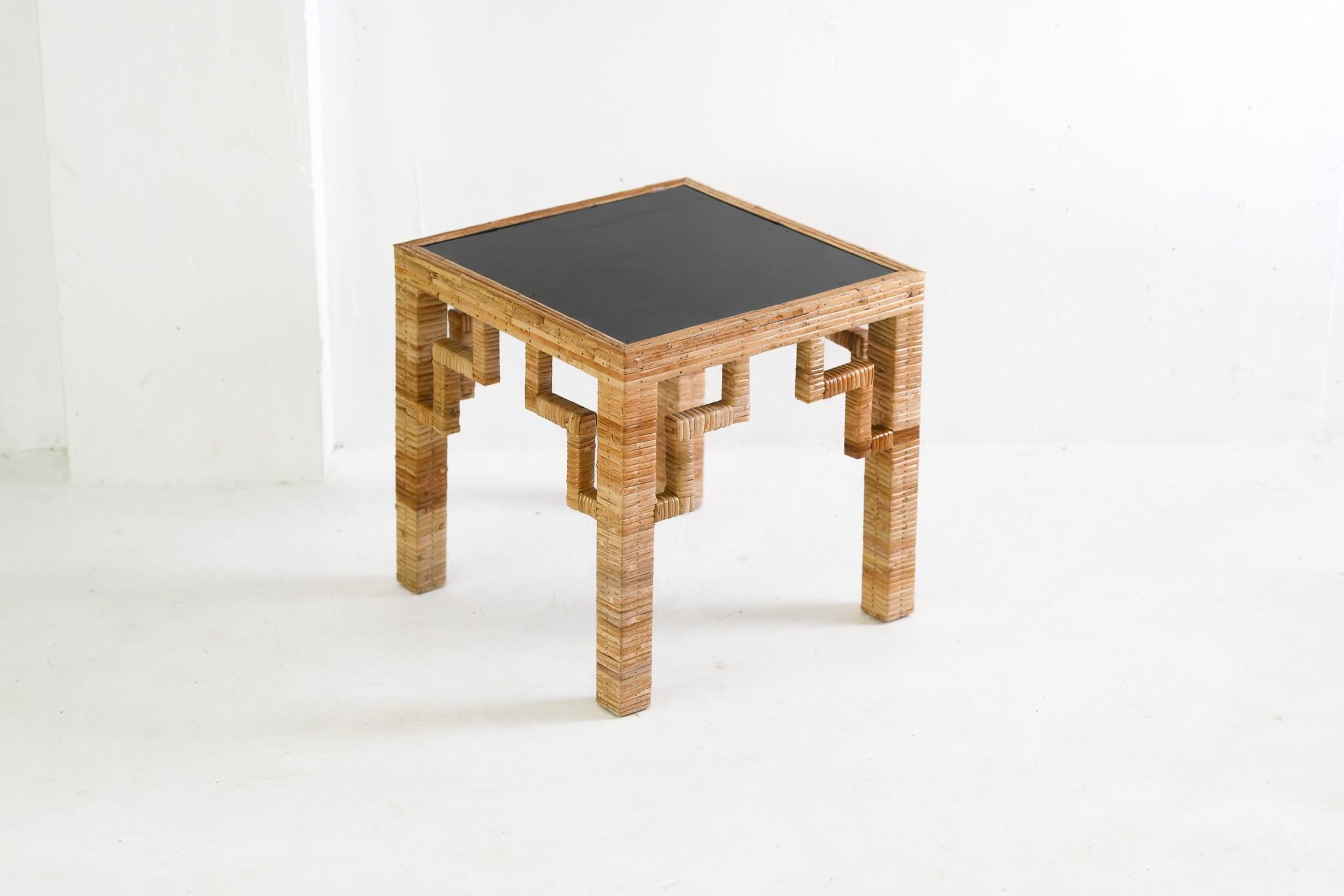 Small table with a black top and wooden frame on a white background