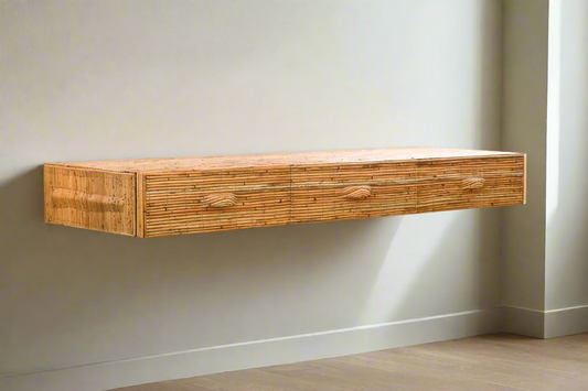Wooden floating shelf with two drawers against a plain wall.