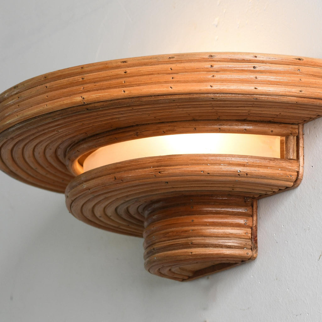 UFoo Wall Sconce — curved saucer silhouette in layered rattan, natural honey brown
