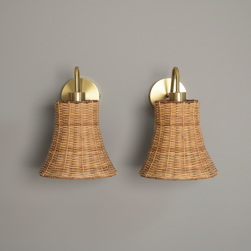 Pair of bell-shaped wicker and brass wall sconces on grey background