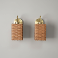 Pair of square rattan and brass wall sconces on grey background